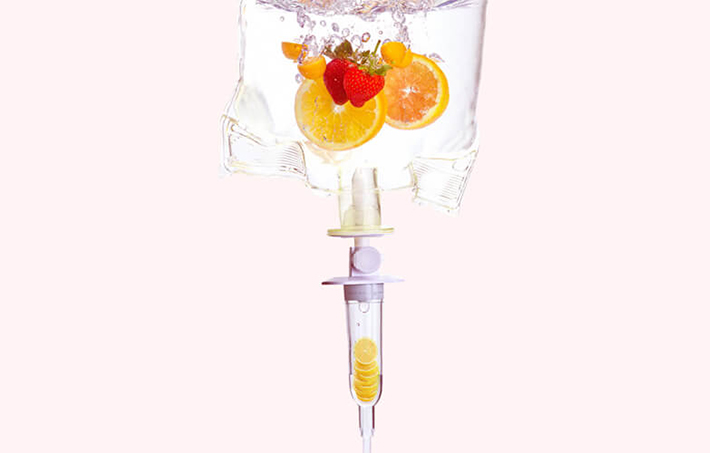 Double detox vitamin drip surrounded by fruit, vegetables and ingredients